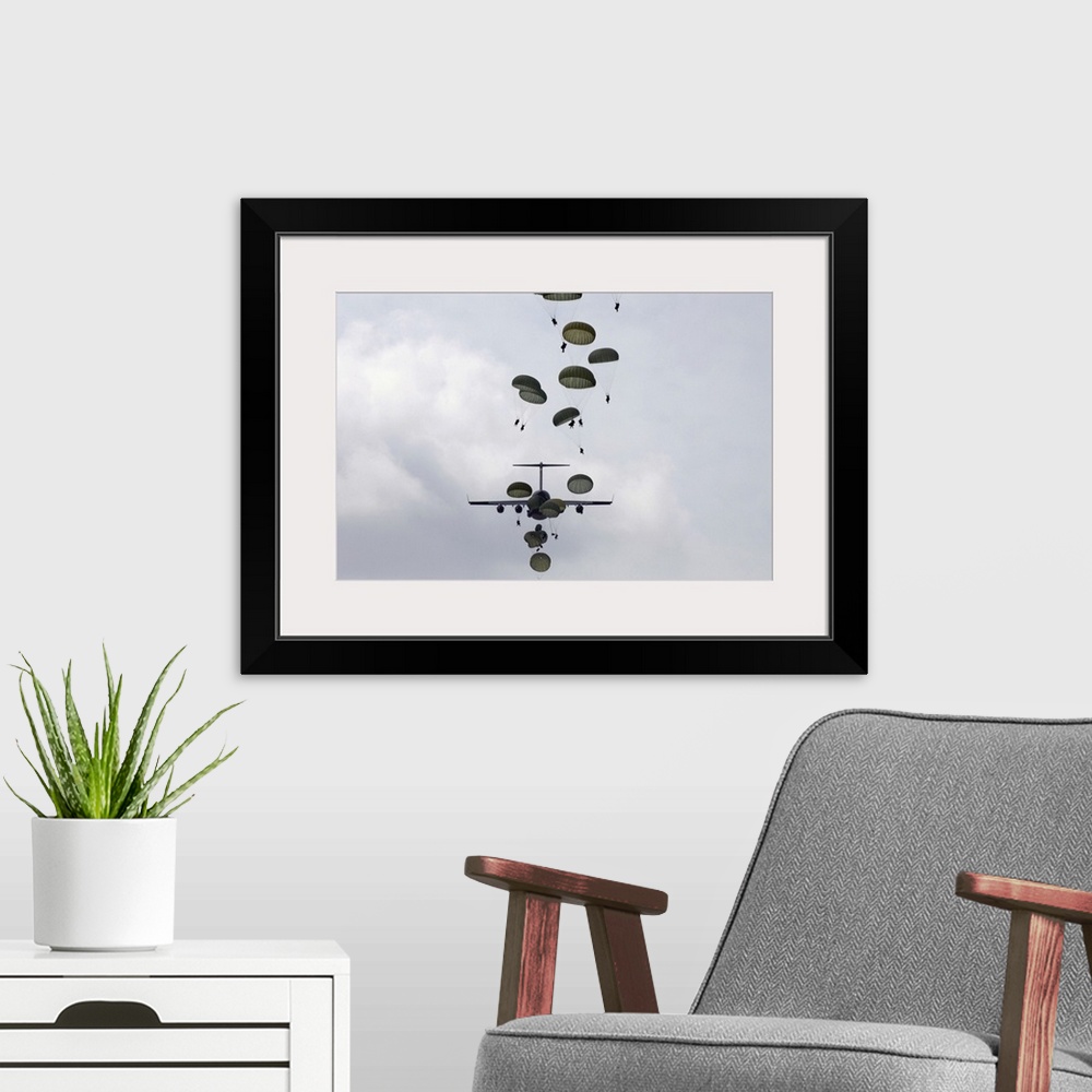 A modern room featuring Wall art of soldiers parachuting from planes.