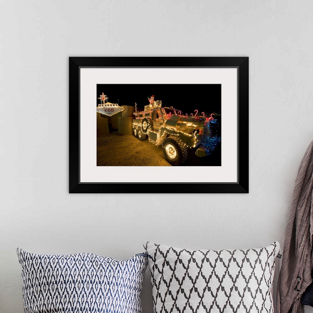 A bohemian room featuring Cougar MRAP is adorned in holiday lights parked in front of EOD Iraq