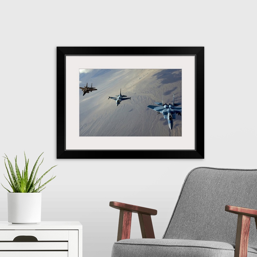 A modern room featuring Big photo on canvas of three fighter jets flying in a diagonal line formation above a desert.
