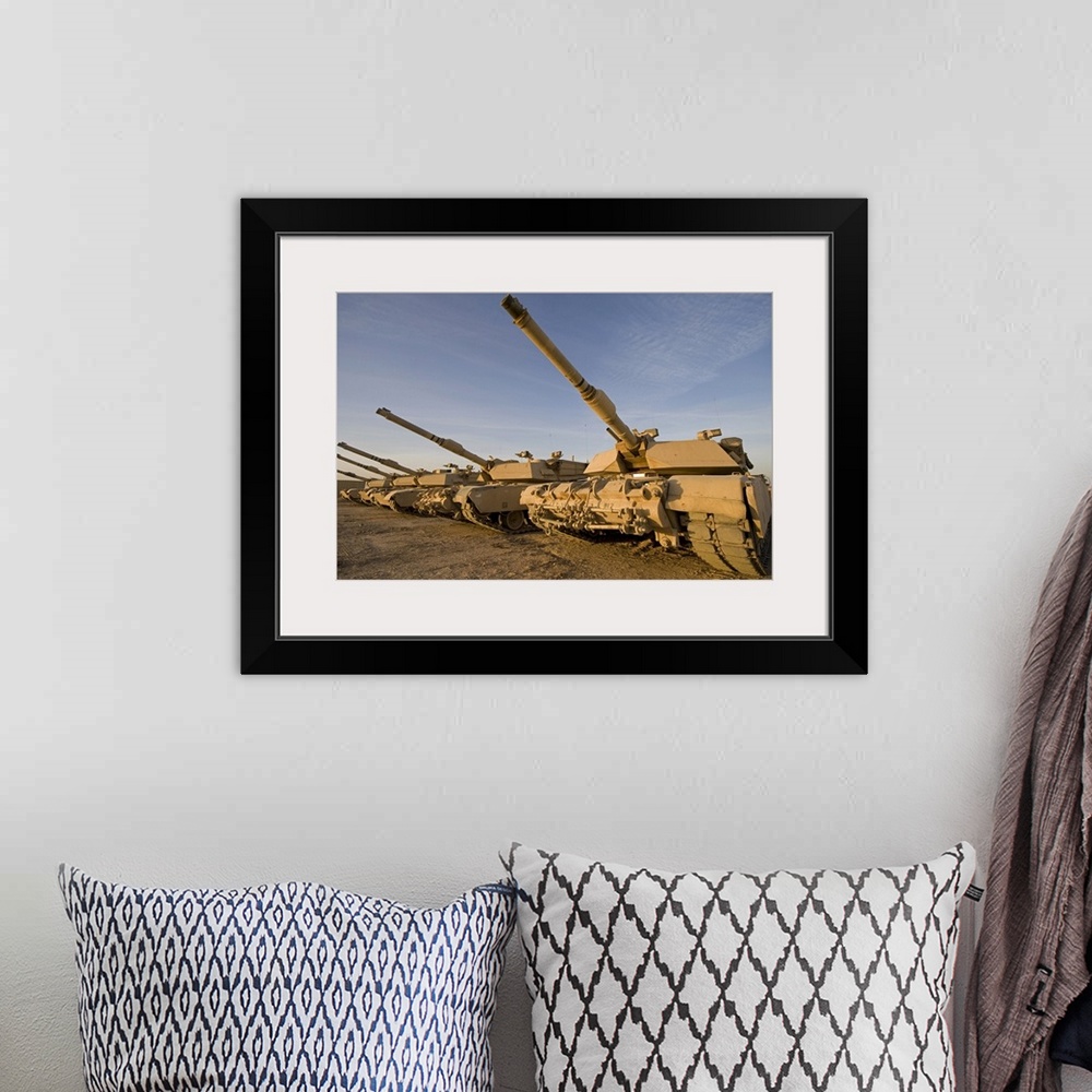 A bohemian room featuring Photograph taken of large military tanks parked in the desert.