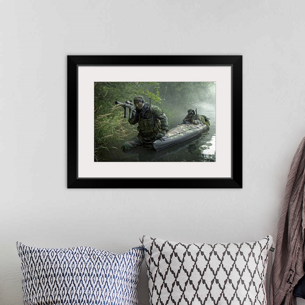 A bohemian room featuring A dramatic photograph of soldiers as they walk through water armed and ready.