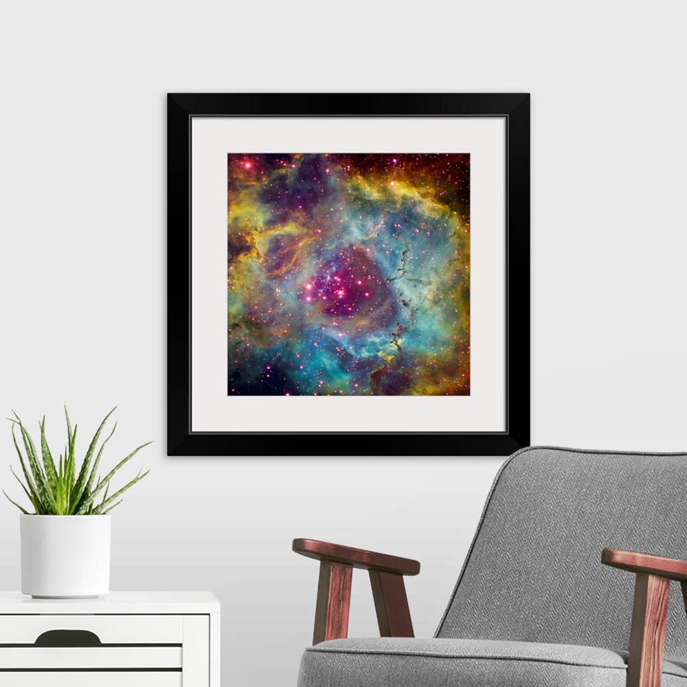 A modern room featuring Large square photograph taken of a star filled sky against the vibrant background of Rosette Nebu...