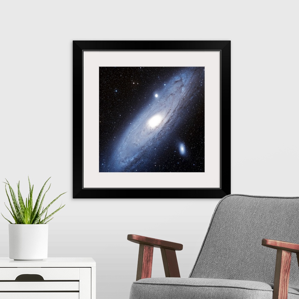 A modern room featuring Photograph of star system with diagonally slanted oval shaped cloud of gas.
