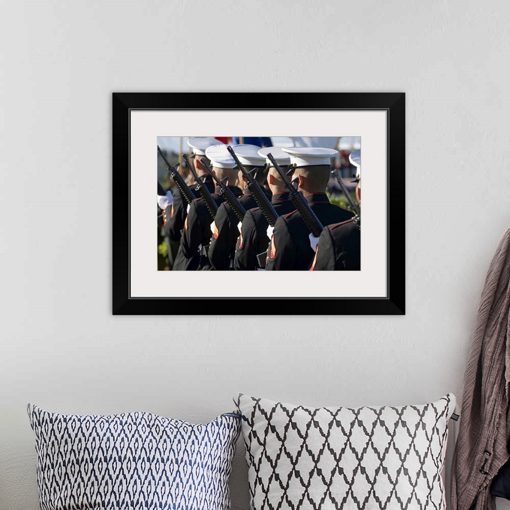A bohemian room featuring Big canvas photo of Marines holding rifles lined up facing away from the camera.