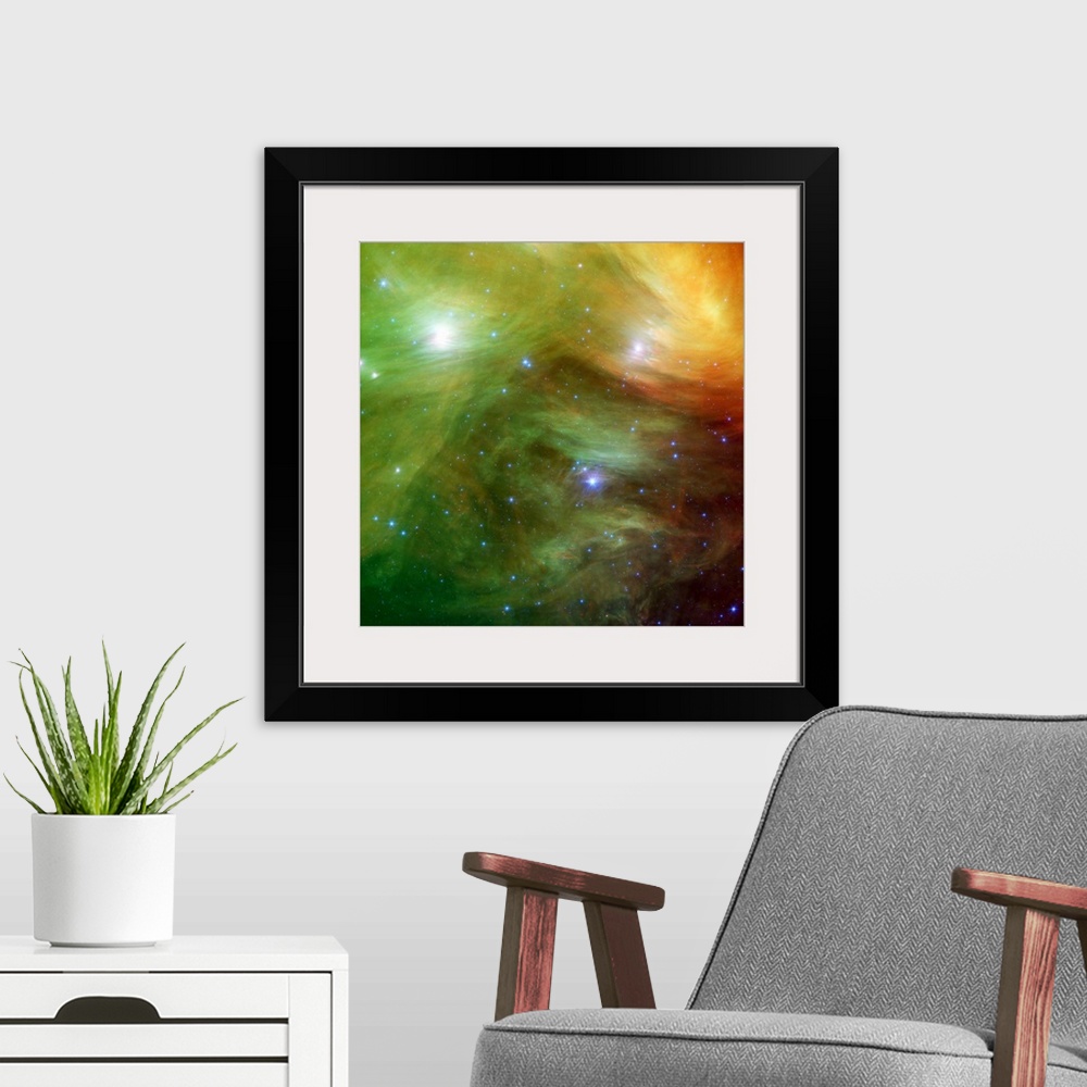 A modern room featuring Big square canvas art of a vividly colored solar system with stars of various sizes.