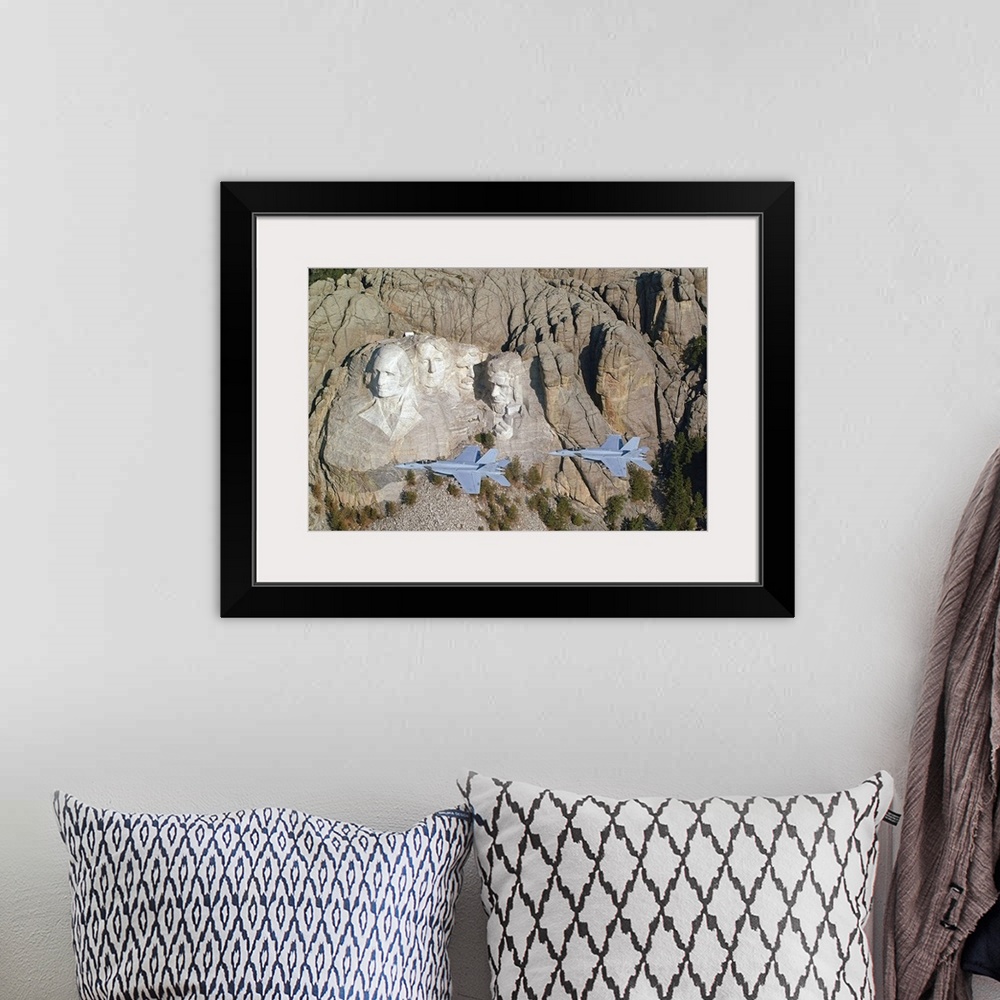 A bohemian room featuring Two military aircrafts are photographed flying by Mount Rushmore.