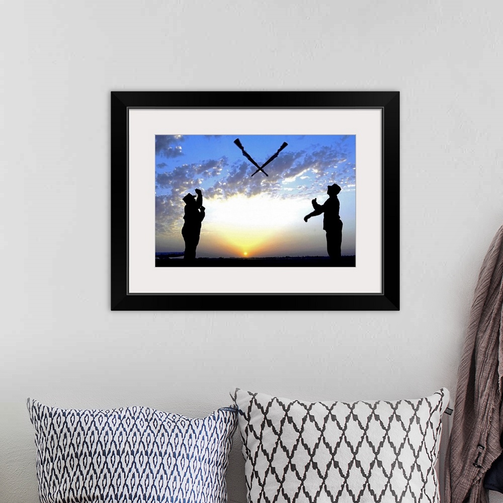 A bohemian room featuring Photograph of two silhouetted soldiers tossing rifles with sunset in distance under a cloudy sky.