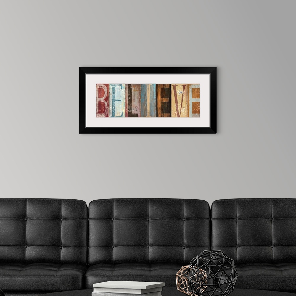 A modern room featuring The word "Believe" with each letter painted in a different style in muted colors, with a worn, we...