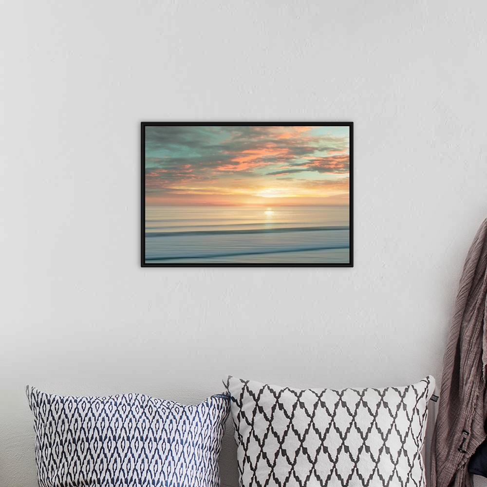 A bohemian room featuring A peaceful scene of the sun slowly rising over a calm stretch of ocean. The sky glows in shades o...