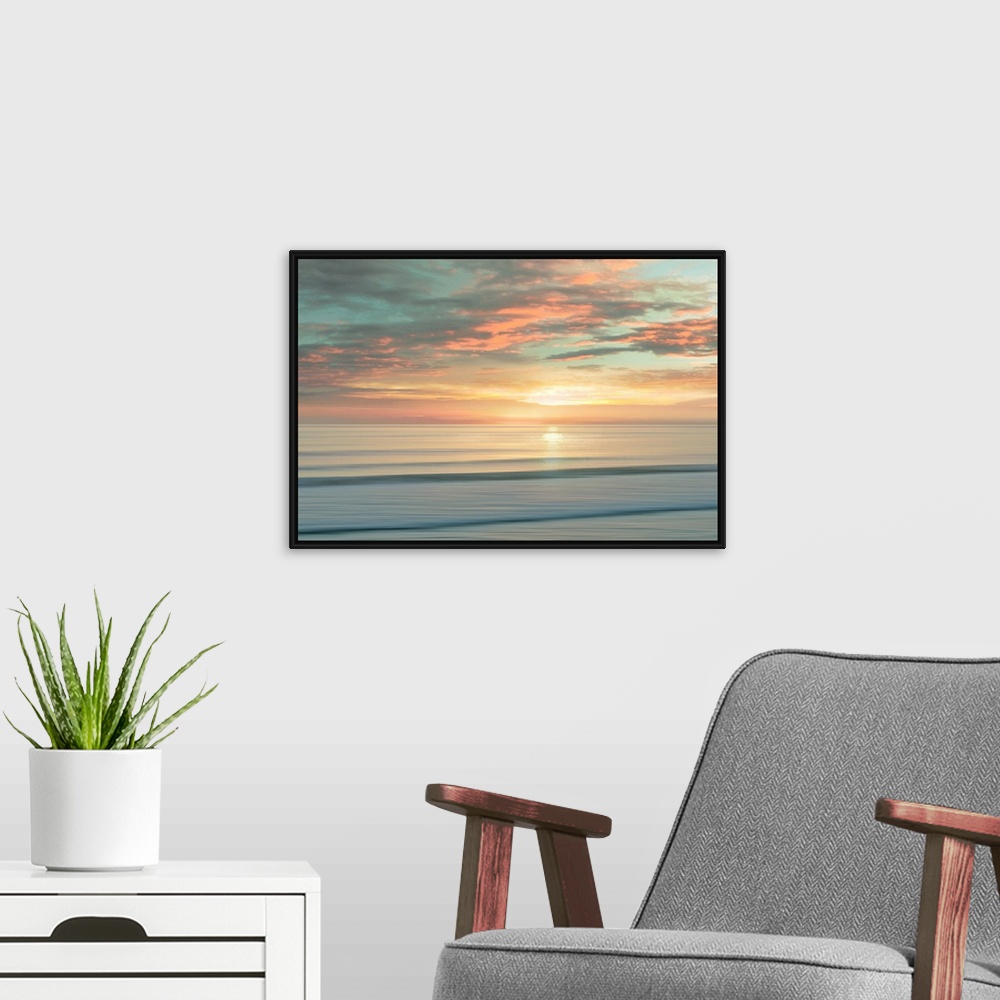 A modern room featuring A peaceful scene of the sun slowly rising over a calm stretch of ocean. The sky glows in shades o...