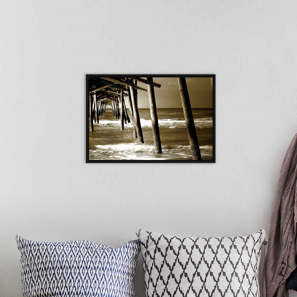 A bohemian room featuring Photograph underneath a wooden pier with waves rolling in.