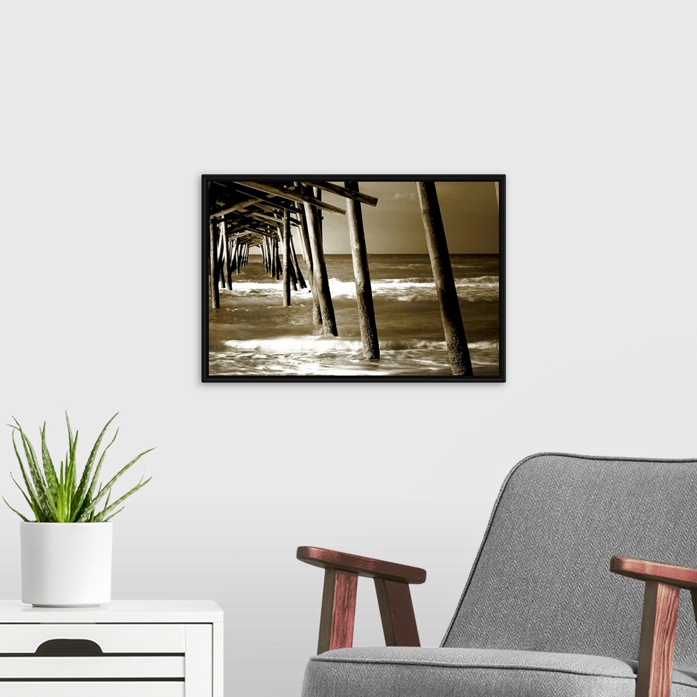 A modern room featuring Photograph underneath a wooden pier with waves rolling in.