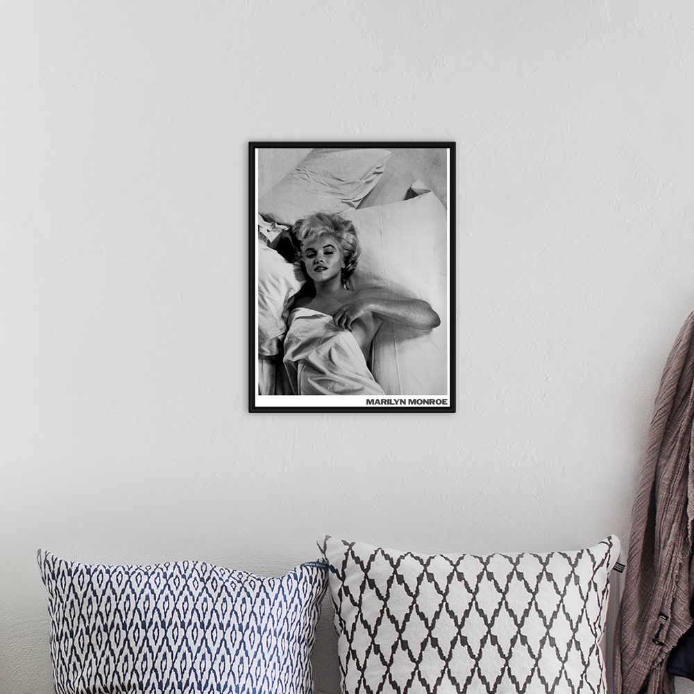 A bohemian room featuring Large monochromatic photograph shows a famous American actress, model, and singer laying in bed w...