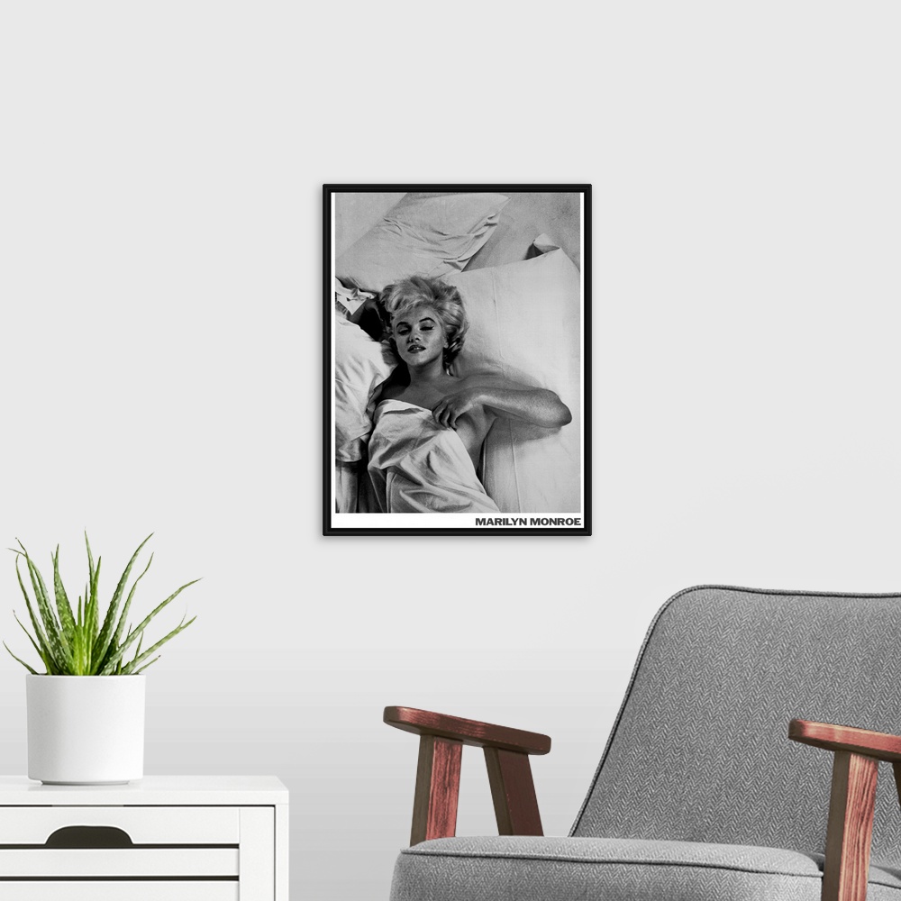 A modern room featuring Large monochromatic photograph shows a famous American actress, model, and singer laying in bed w...