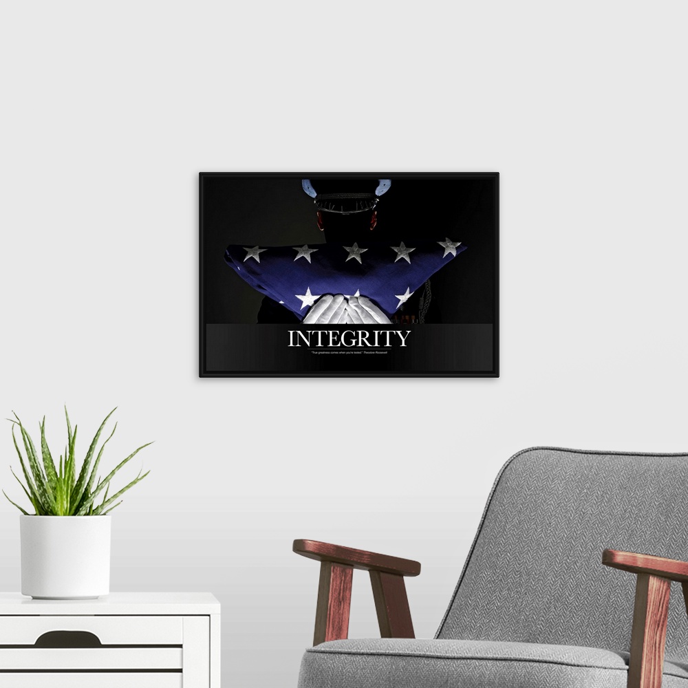 A modern room featuring A silhouette of a soldier is shown as he holds up a folded American flag. The word "Integrity" is...