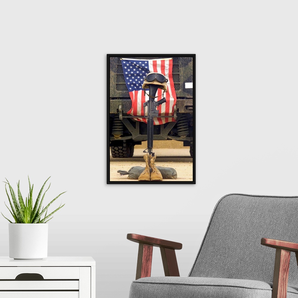 A modern room featuring Tall photo on canvas of a rifle sticking out of two boots with a helmet on top in front of an Ame...