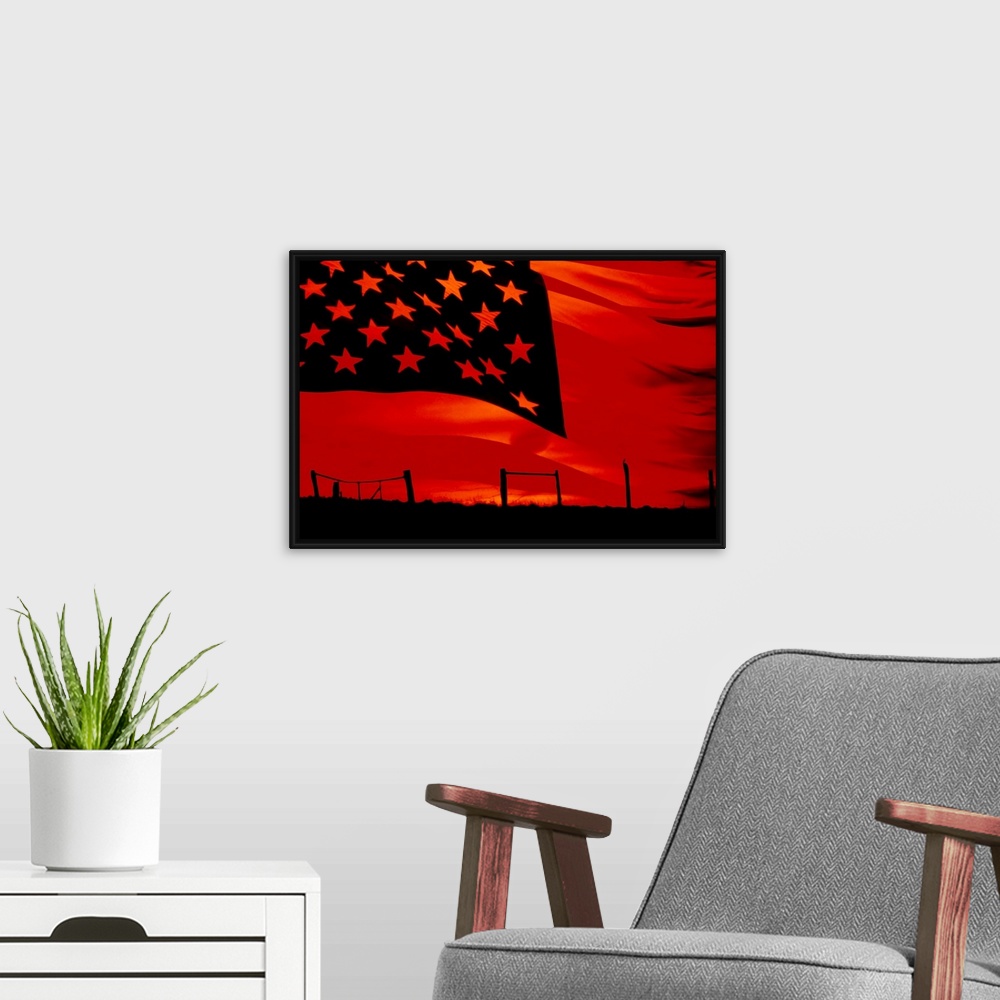 A modern room featuring Huge photograph displays a broken fence in a desolate field as the sun begins to set.  Photograph...