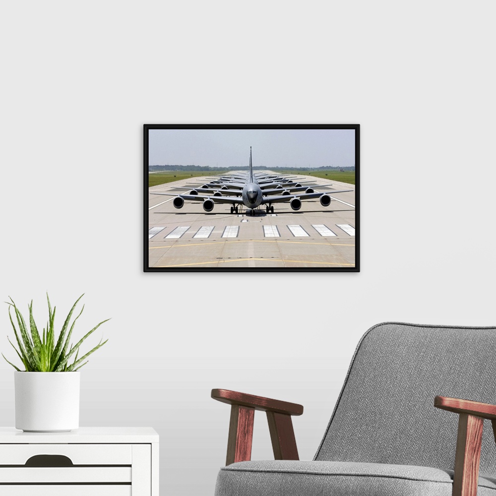 A modern room featuring Photograph of several large Stratotanker airplanes perfectly lined up in a row on a runway.