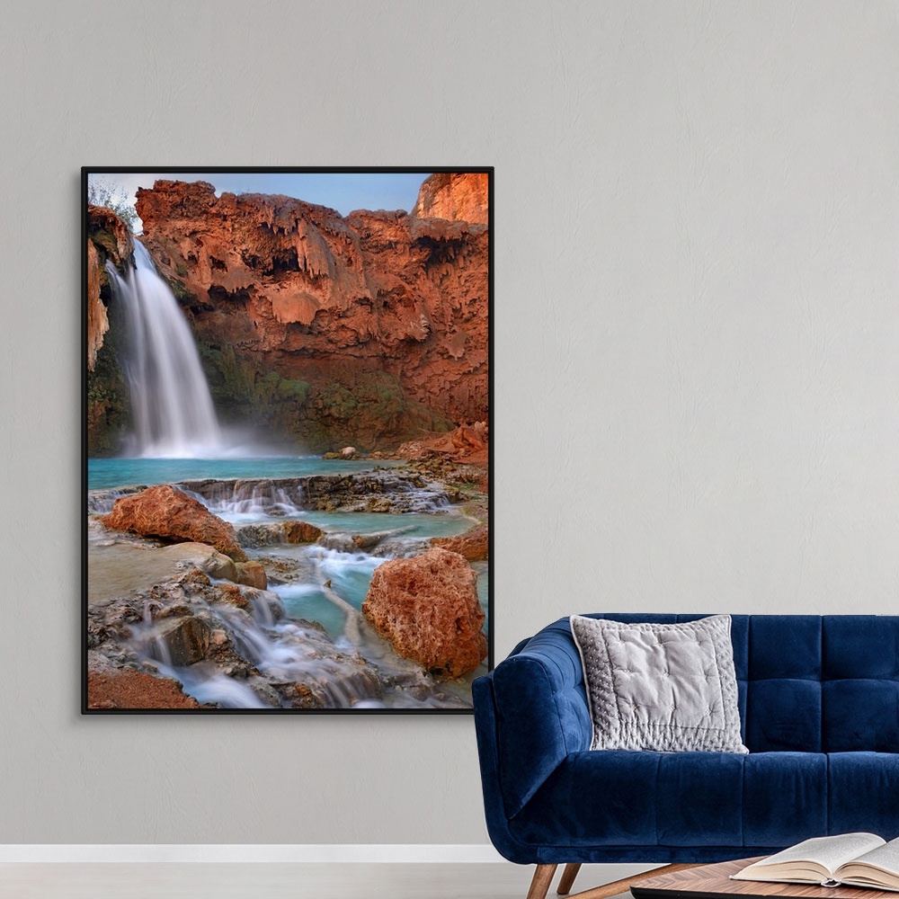 A modern room featuring Large photograph showcases water falling down a jagged cliff and splashing into the pool below be...