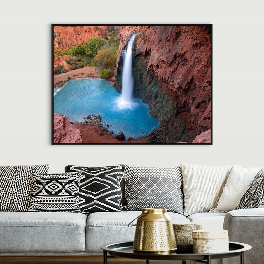 A bohemian room featuring Large photograph taken of a waterfall crashing into the clear water below.  This portion of the c...