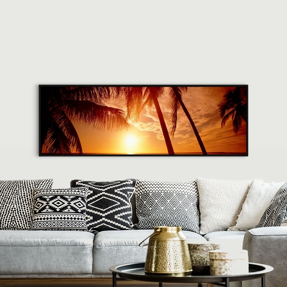 A bohemian room featuring Large panoramic wall photograph of palm trees waving in front of a golden sunset in Fort Meyers, ...