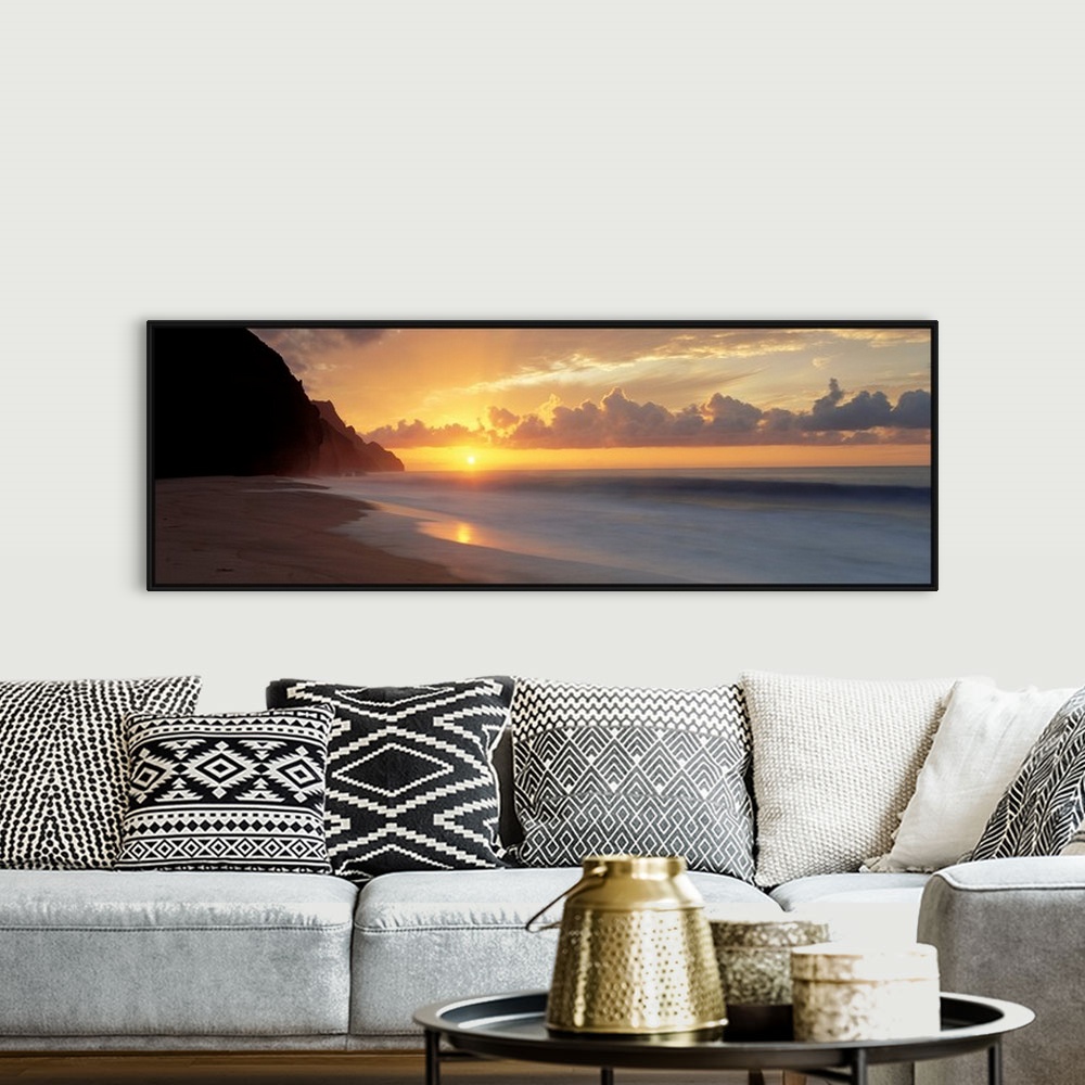 A bohemian room featuring The sun sinks below the horizon viewed from the beach on a tropical Pacific island.