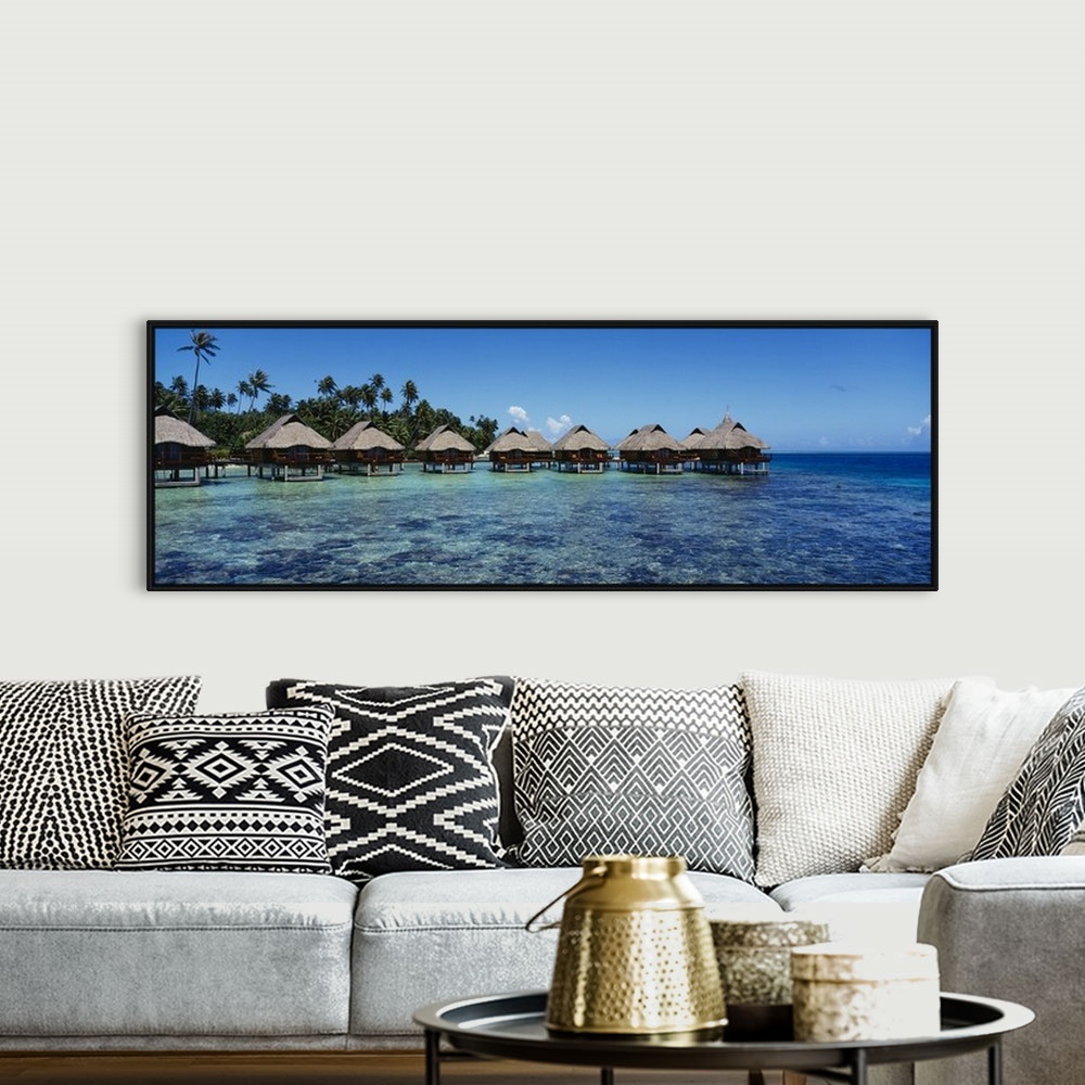 A bohemian room featuring Panoramic photograph showcases a row of small shacks sitting in the middle of clear water from th...