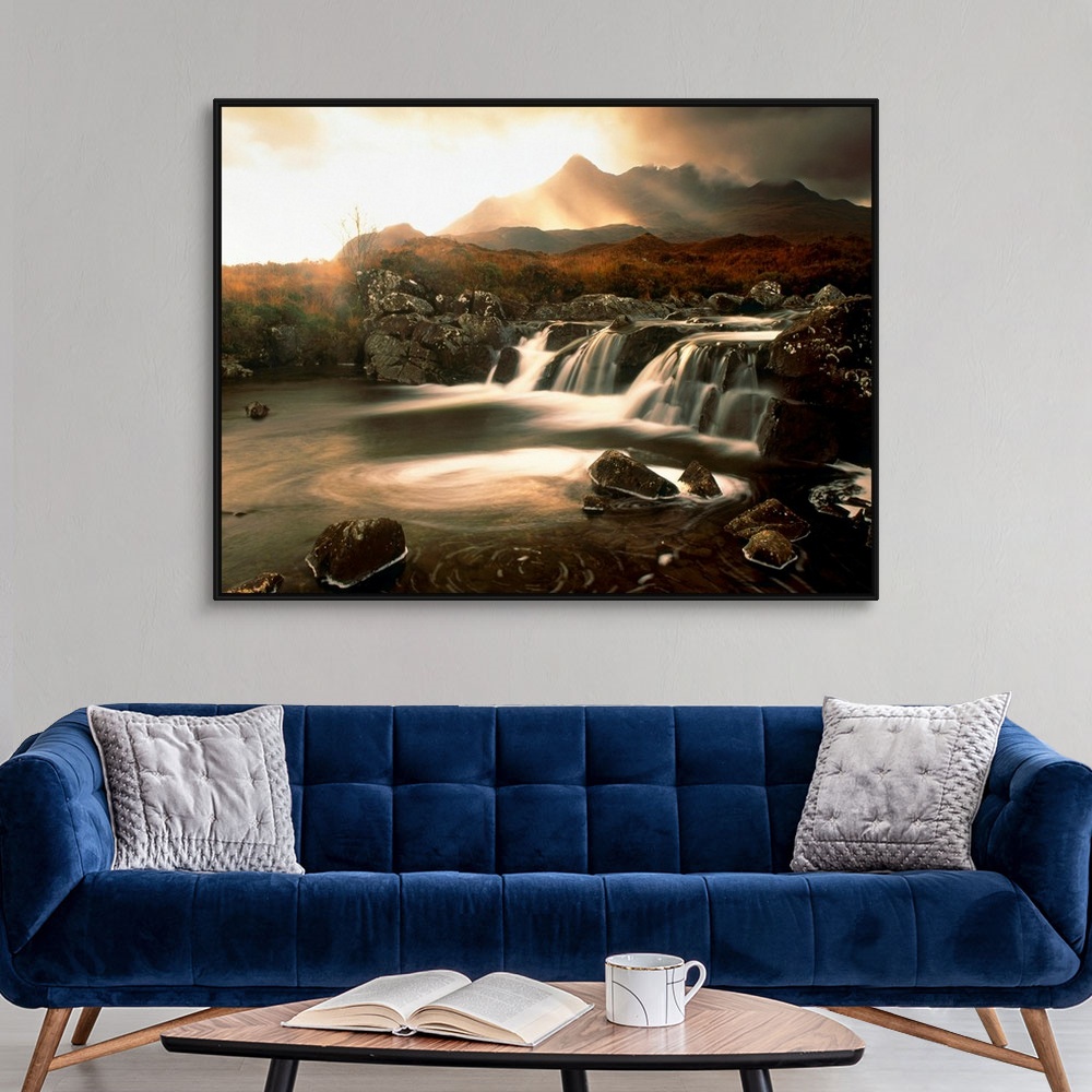 A modern room featuring Time lapsed photograph of water flowing through a rocky river while the sun glows behind clouds i...
