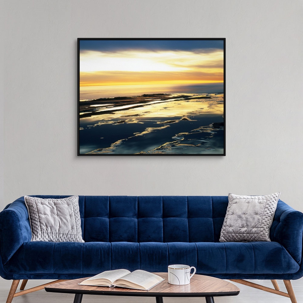 A modern room featuring Giant photograph taken from an aerial view shows the Pacific Ocean as it begins to make its way t...