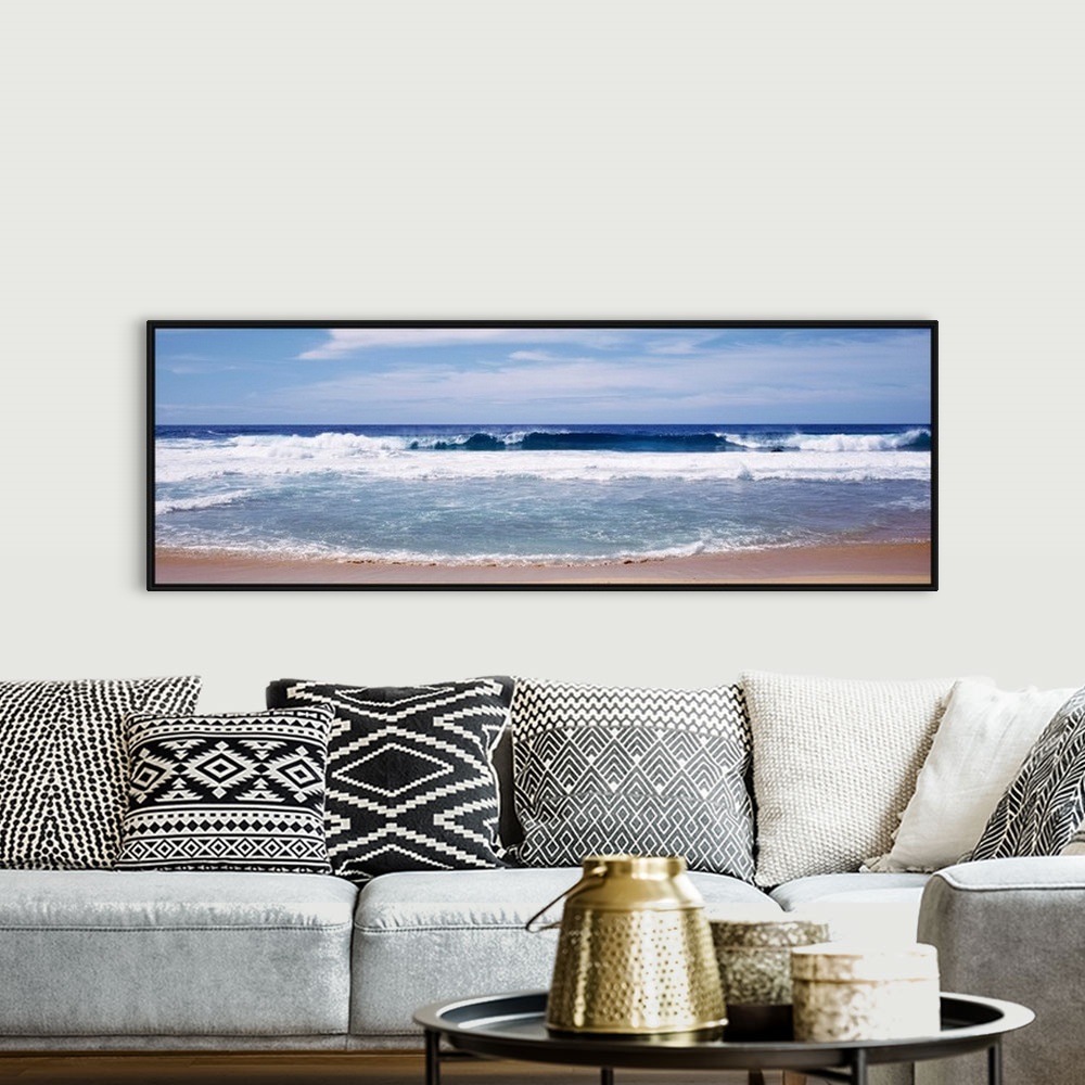 A bohemian room featuring Panoramic photograph displays the waves of an ocean aggressively crashing into a sandy beach on a...