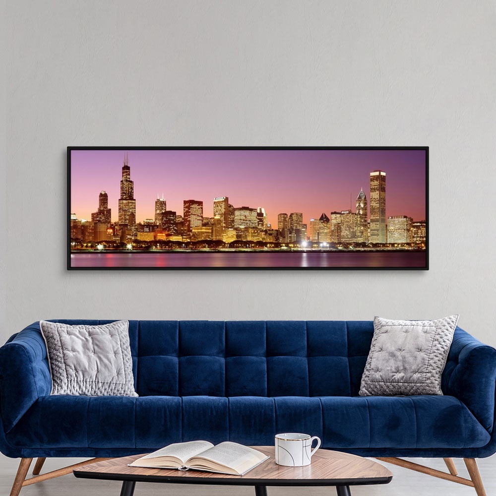 A modern room featuring A panoramic photograph of a skyscraper filled skyline taken at dusk in Chicago, Illinois.  The br...