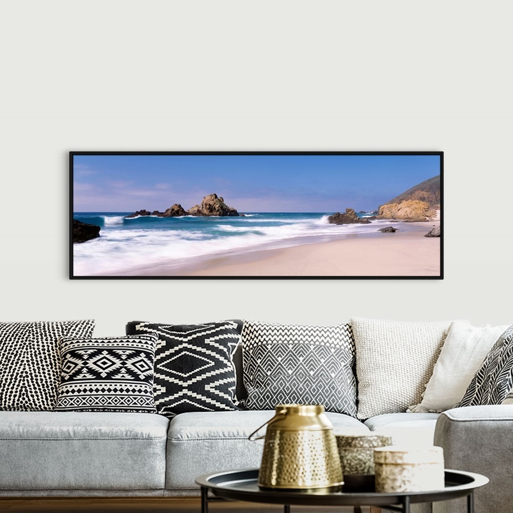 A bohemian room featuring Panoramic photographs displays the Pacific Ocean crashing into the sandy shores of this beach.  L...