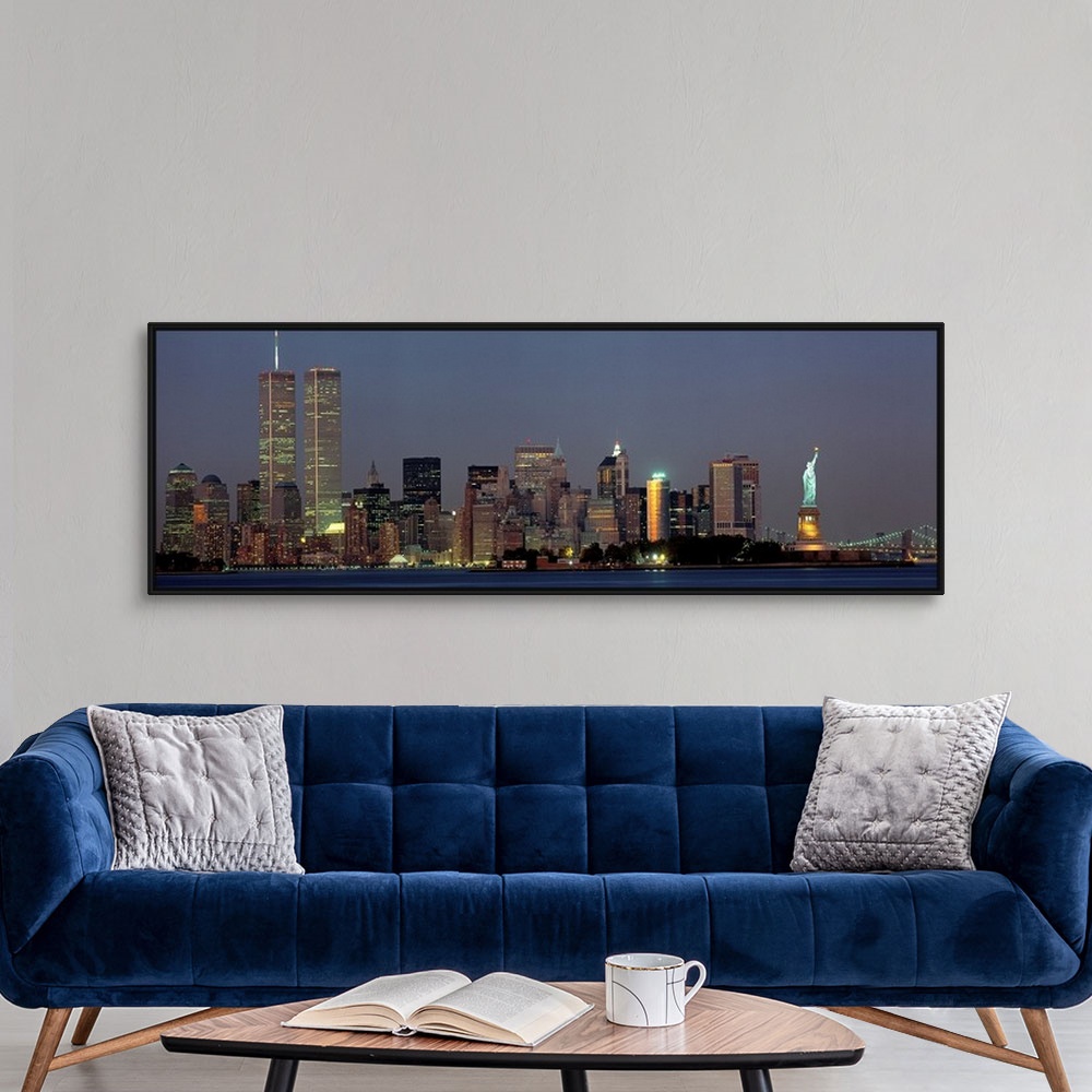 A modern room featuring Panoramic photograph of the New York skyline at night, with the Twin Towers and the Statue of Lib...