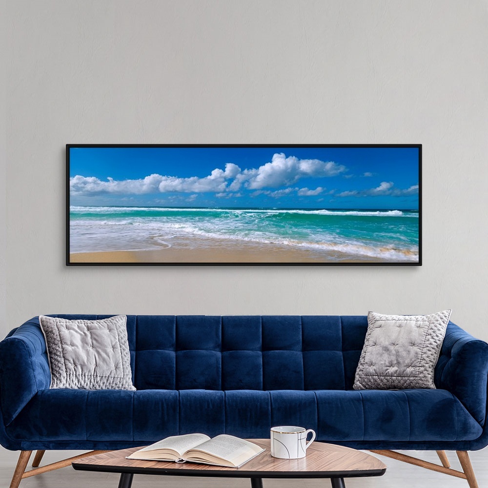 A modern room featuring Panoramic view of a Hawaiian beach where waves are washing up on the shore while the wind blows c...