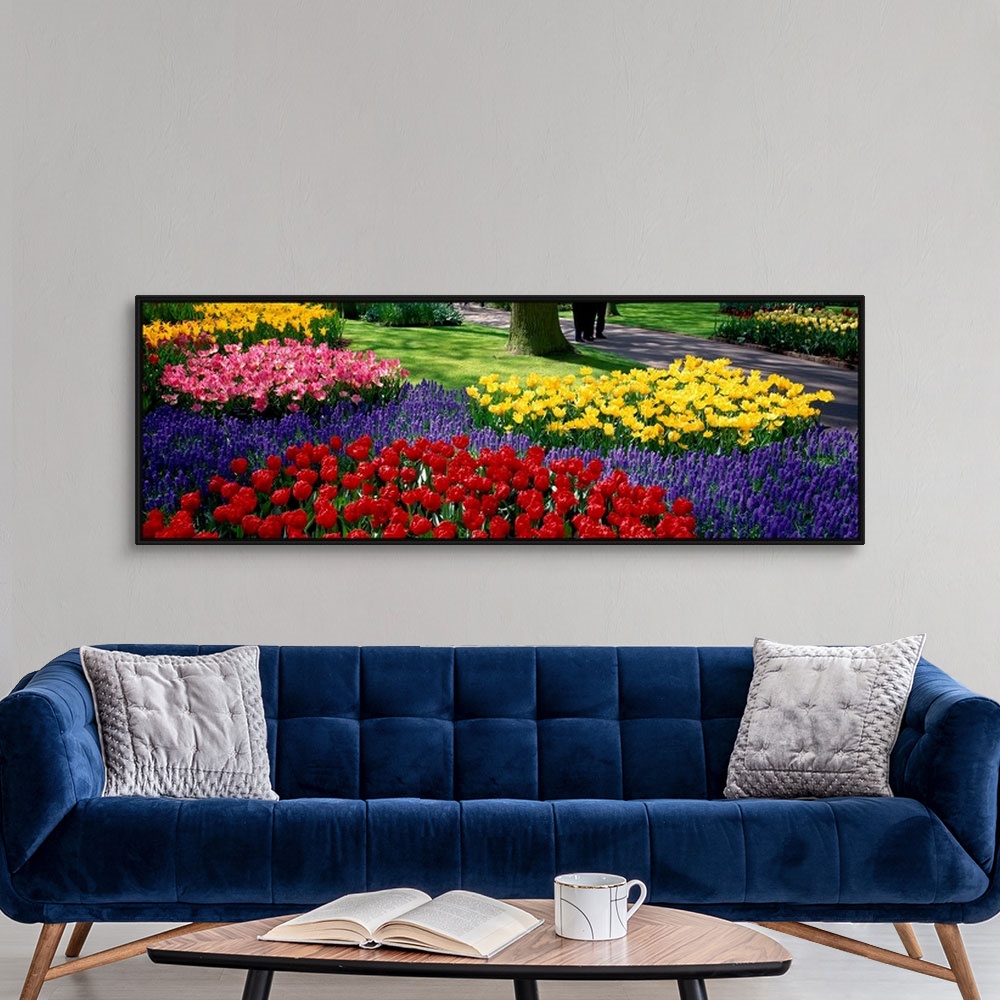 A modern room featuring Panoramic photograph displays various groups of vibrantly colored flowers as they sit near the ed...