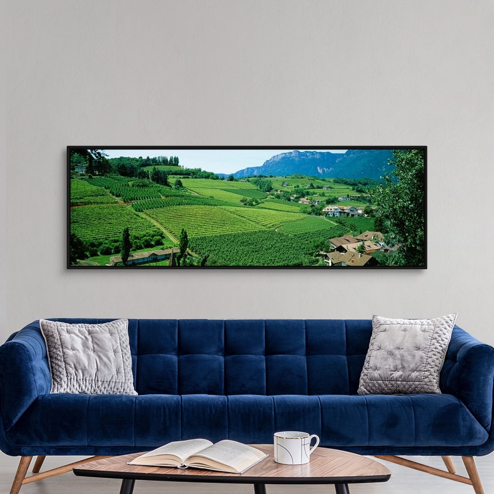 A modern room featuring Panoramic photograph displays the rolling countryside of a European country scattered with houses...