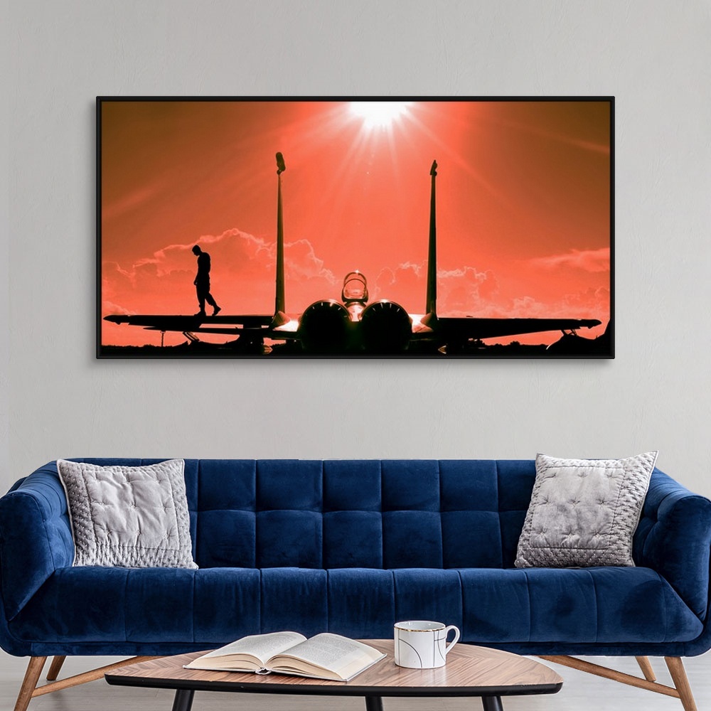 A modern room featuring Long canvas of the silhouette of a pilot walking on the wing of a jet parked on the tarmac.